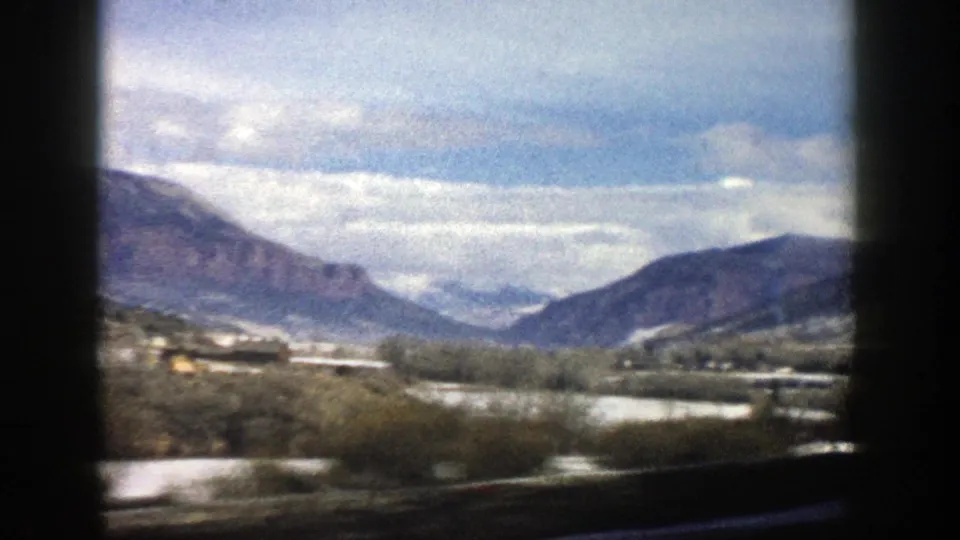 1961 Aspen, Colorado home-movie view of a snowy valley and distant mountains filmed from a moving vehicle.