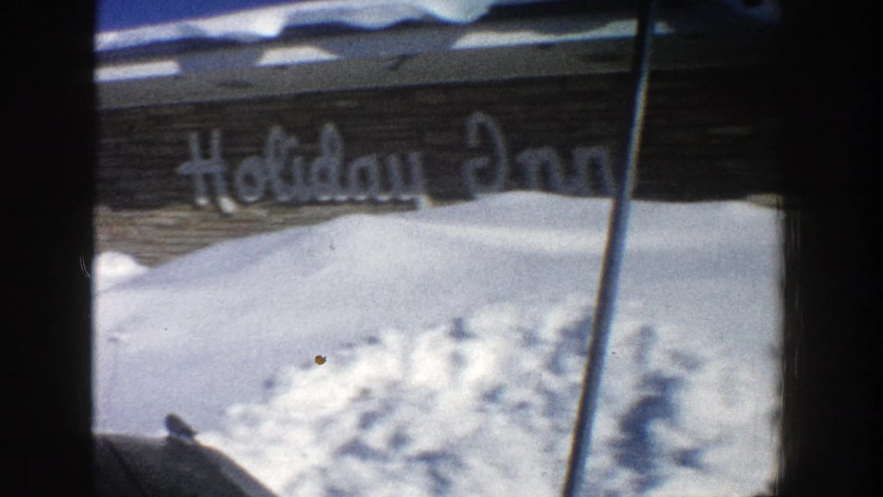 Snow piled in front of a building with a visible Holiday Inn sign.