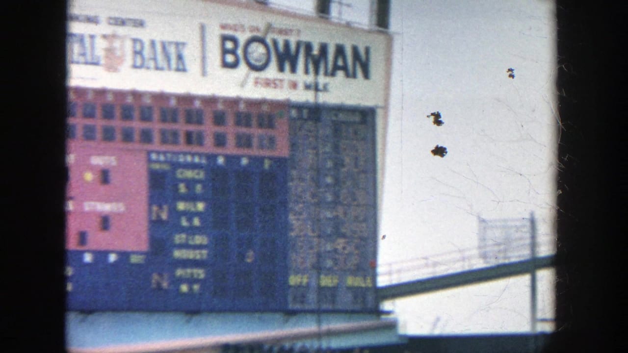 Scoreboard section with Continental Bank and Bowman signs behind a dark post.