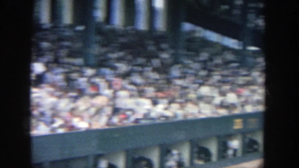 Crowd-filled upper seating at Yankee Stadium, seen through soft 8mm focus and handheld framing.