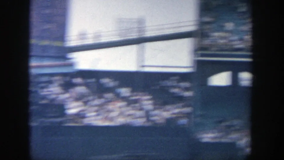 Handheld 8mm pan across Yankee Stadium seating, with motion blur and bright structural surfaces.
