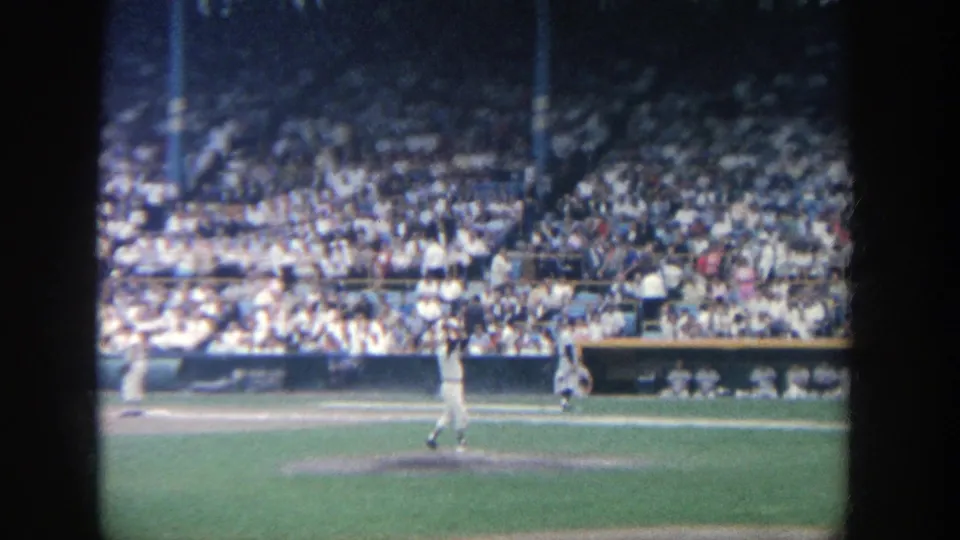 Yankee Stadium game view showing a pitcher on the mound with packed bleachers in the background.