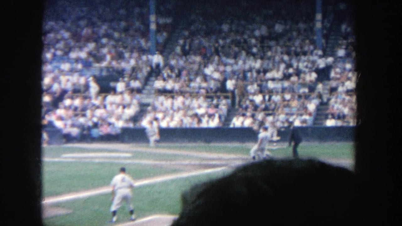 Baseball batter near home plate with catcher, umpire, pitcher, and crowd visible.