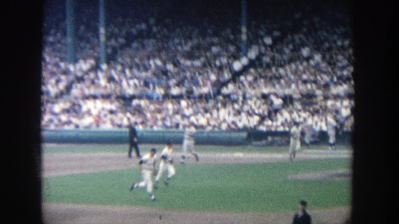 Players run across the infield while the crowd fills the background stands.