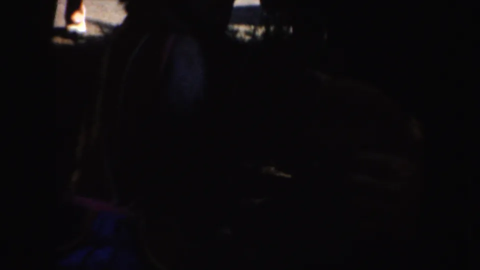 1952 California 8mm frame showing a shadowed costumed figure with visible vest trim in low light.