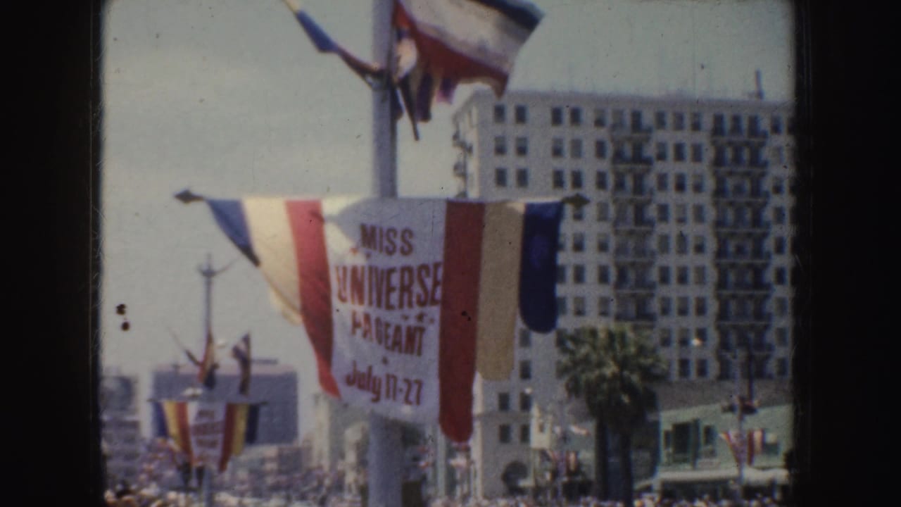 Miss Universe Pageant banner and flags above a crowded California street.