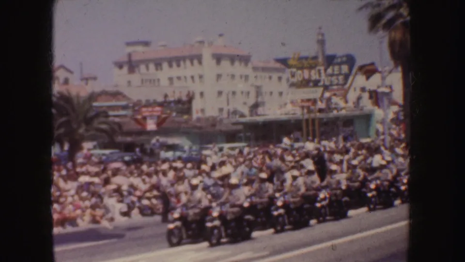 1952 California parade scene with spectators lining the curb as motorcycles pass near a visible House of Jose sign.