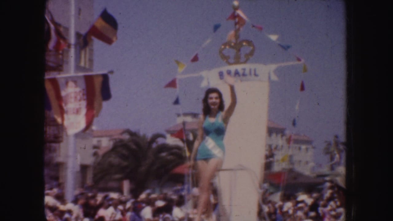 1952 California parade frame showing a beauty queen in turquoise on a float marked Brazil, with bunting, flags, and spectators below.