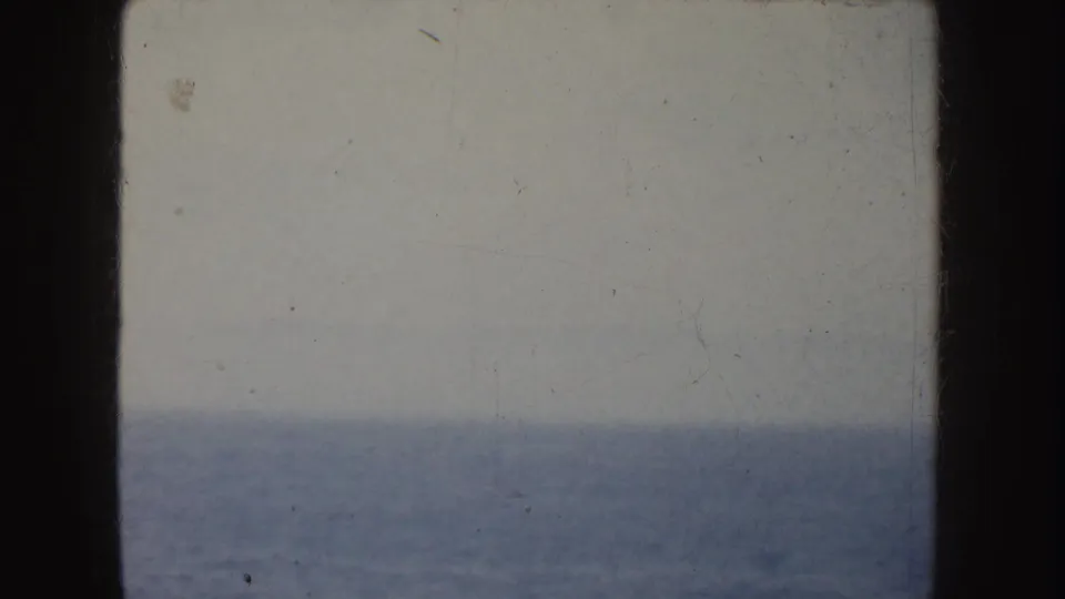 1952 California 8mm view of open ocean beneath a hazy overcast sky, bordered by dark film or window edges.