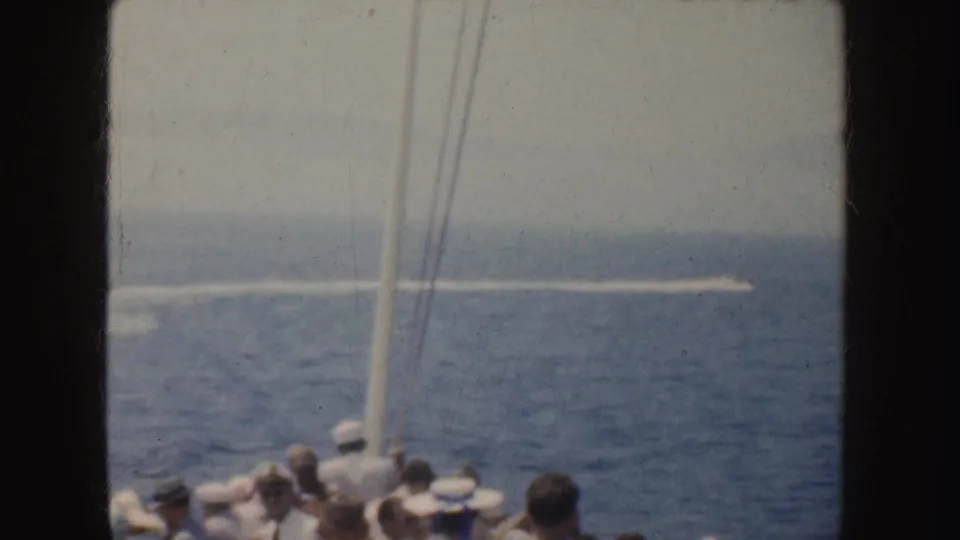 1952 California shipboard view with passengers in hats looking toward a fast motorboat and its white wake on the ocean.