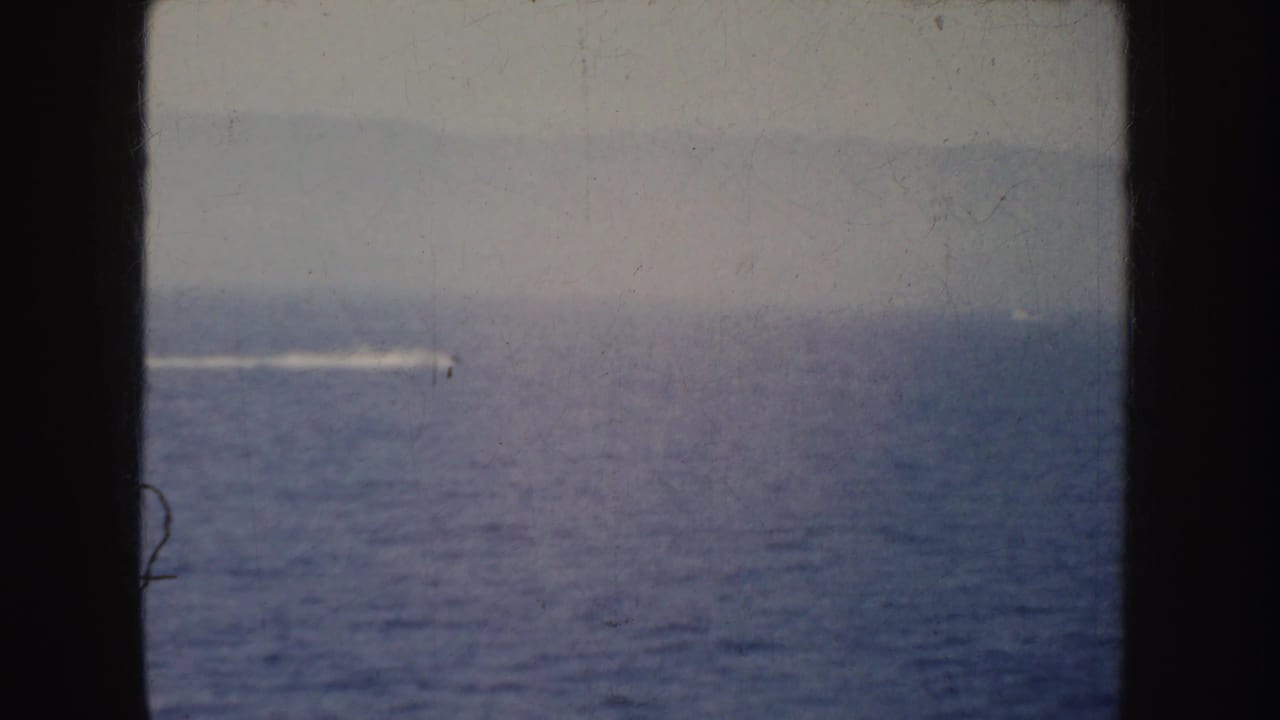 Open water and a distant speedboat wake appear through dark 8mm frame borders in California footage from 1952.