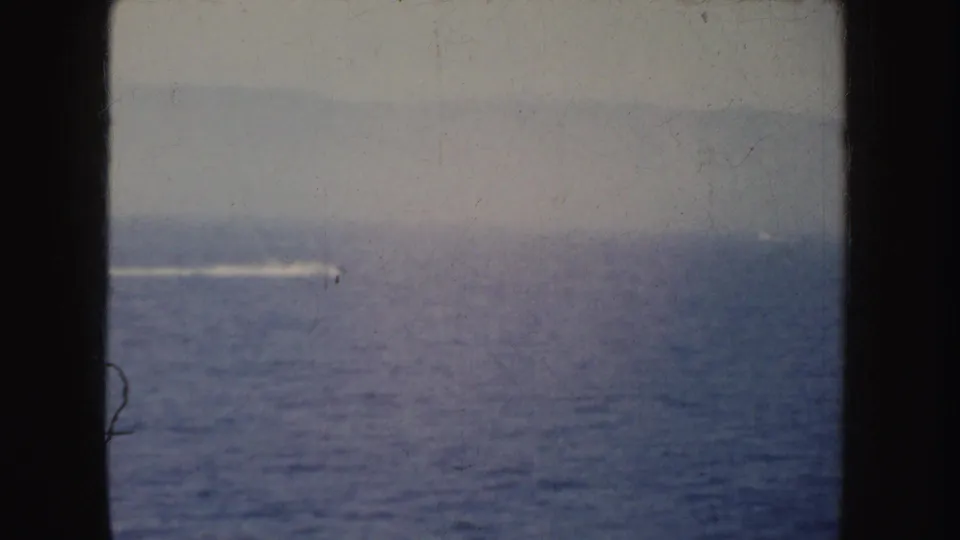 Open water and a distant speedboat wake appear through dark 8mm frame borders in California footage from 1952.
