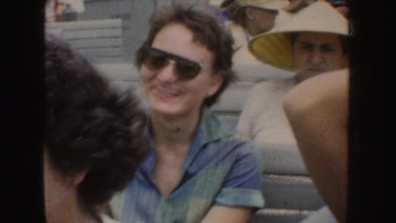 Spectators sit near the camera in 1952 California footage, including a smiling woman in sunglasses and a man in a brimmed hat.