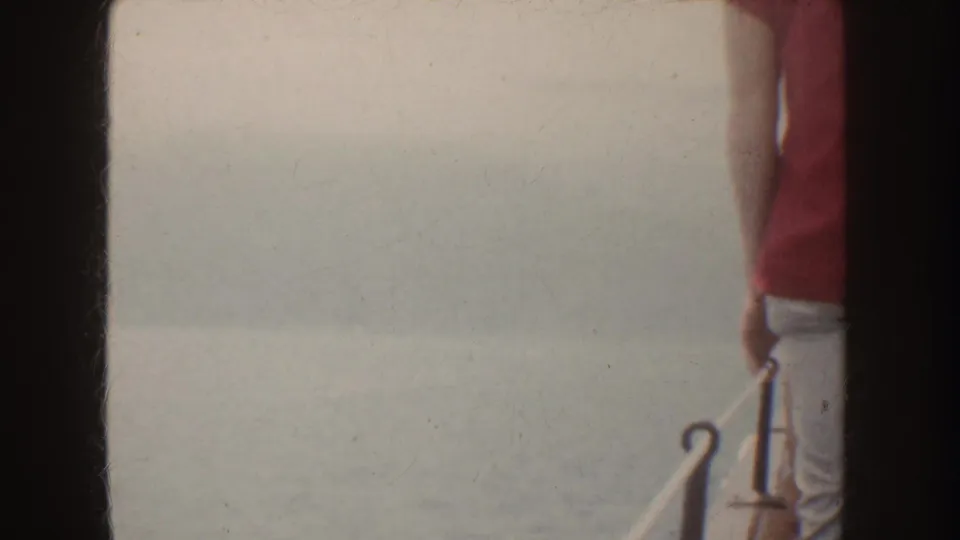 The 1952 California boat footage frame shows mostly overexposed pale background, a partial person at center, and dark film borders.