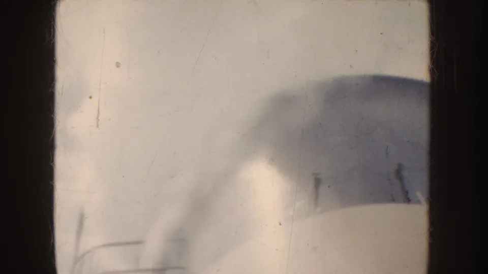 A soft, partial view of a large white vessel or ship structure appears at frame edge in the 1952 California home movie.