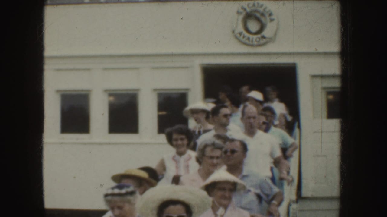 Passengers exit a white bus while others stand near the doorway.