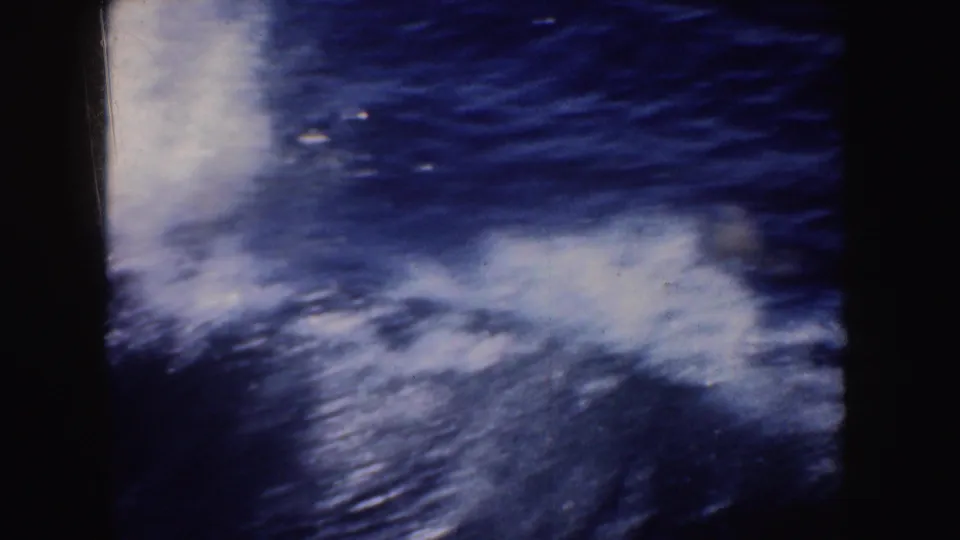 1952 California 8mm frame with blurred white spray and rippling blue water, filmed close to the boat's wake.