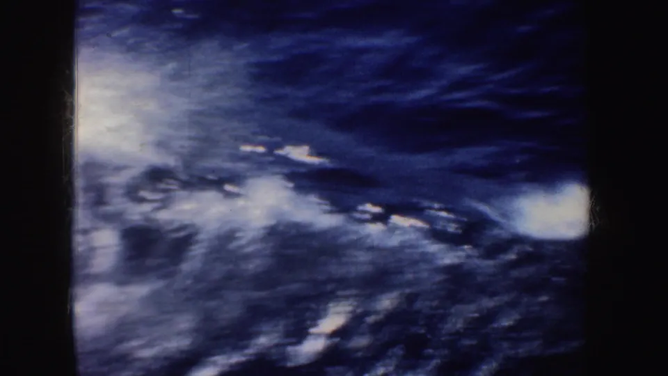 1952 California 8mm frame showing dark blue sea and white wake from a moving boat, with film gate edges visible.