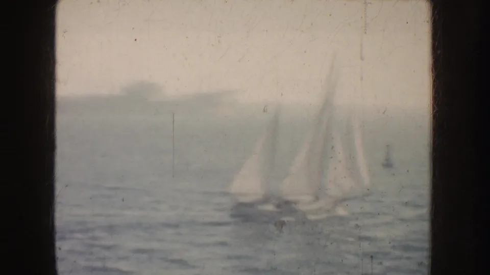 Distant white sailboats appear on hazy California water in a faded 1952 8mm home-movie frame.