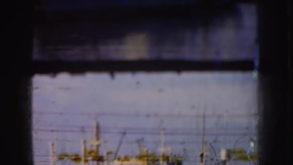 Soft 1952 California harbor frame with distant vessel masts and waterfront details seen through dark 8mm frame edges.