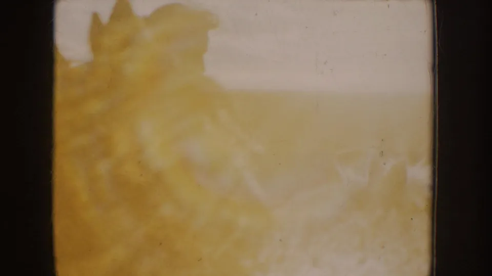 A bright, washed 8mm transition frame shows yellow-white exposure flare with only faint shapes visible.