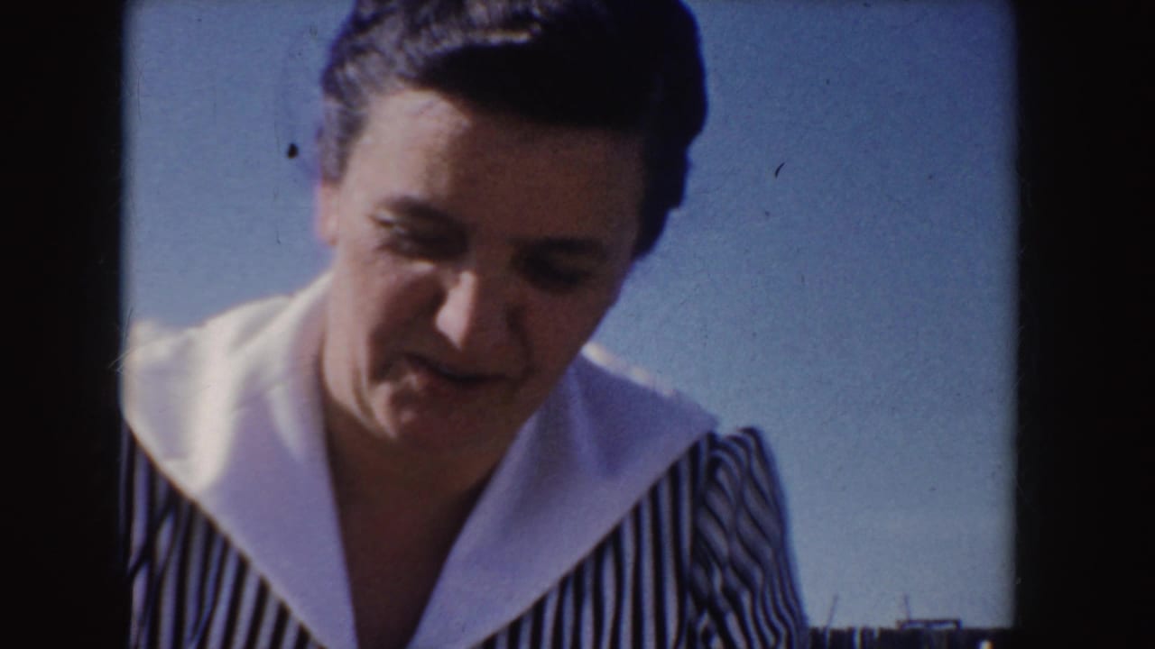 Adult woman looking downward while wearing a striped dress with a white collar.