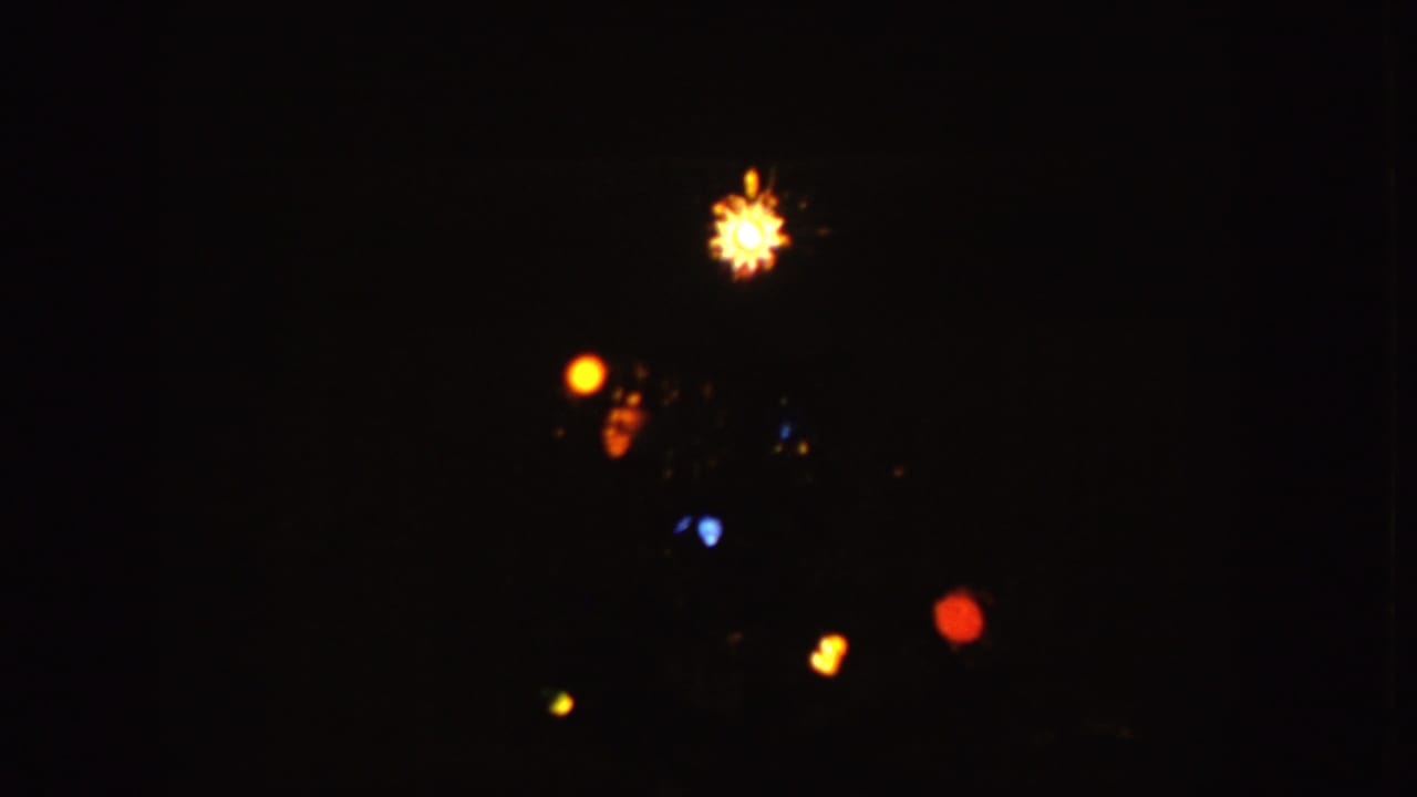 Colored holiday-style lights glowing against a dark background.