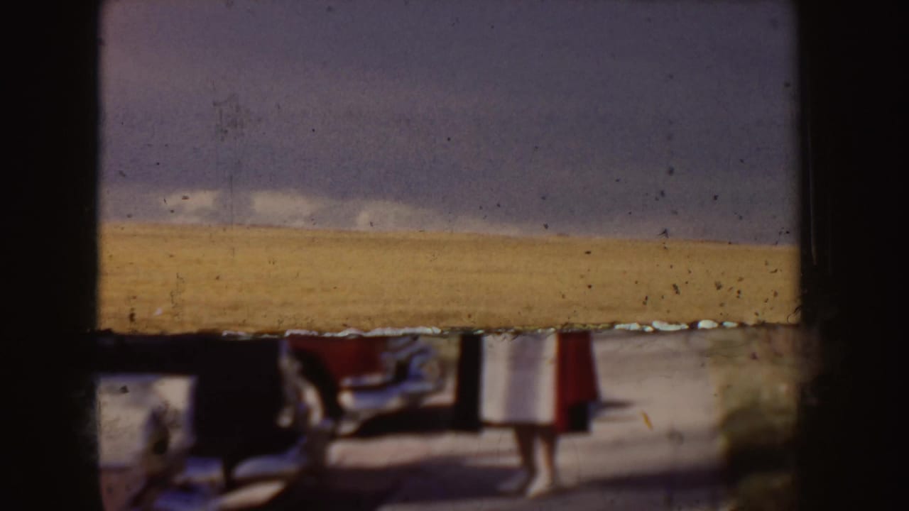 Blurred roadside view with a red and white car and a standing figure partly visible.