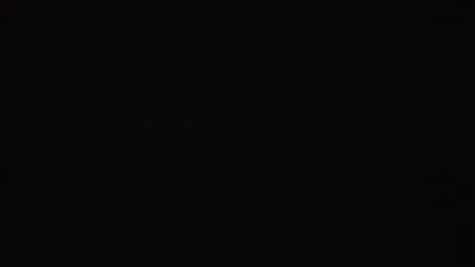 Nearly black frame from the same 8mm clip, with only minimal film texture visible.