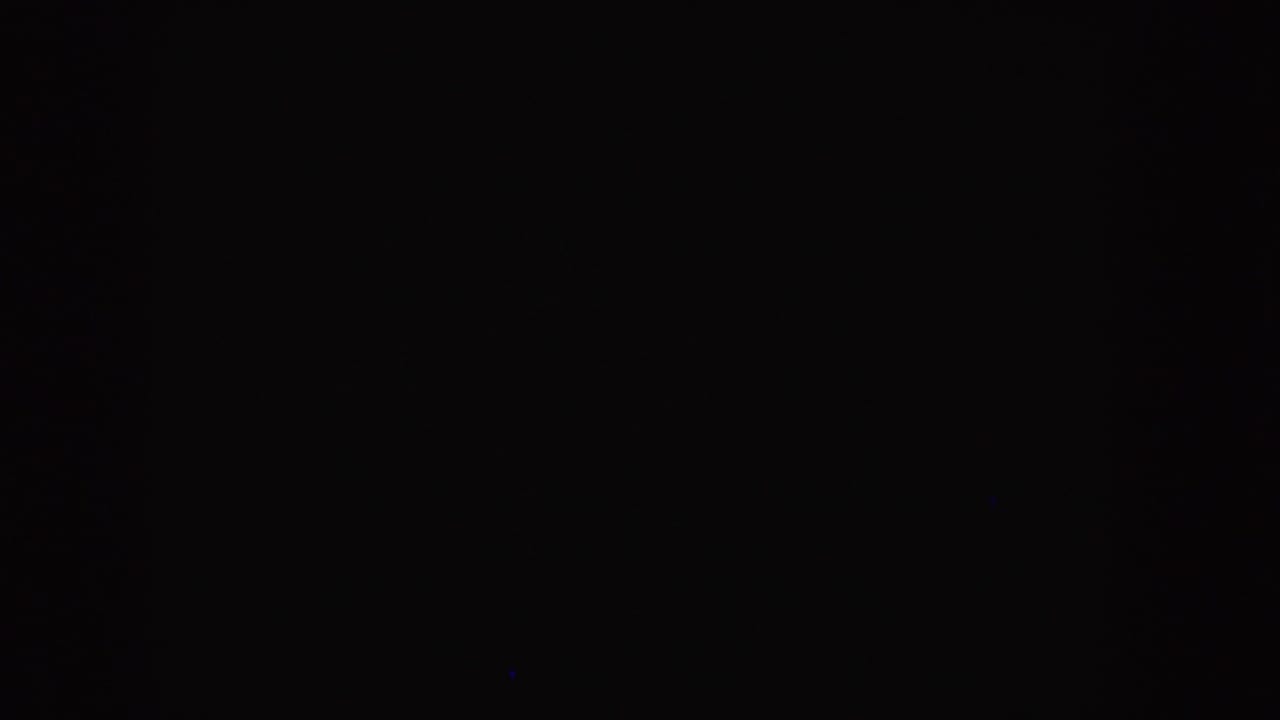 Dark blank film frame with slight grain and minimal speckling.