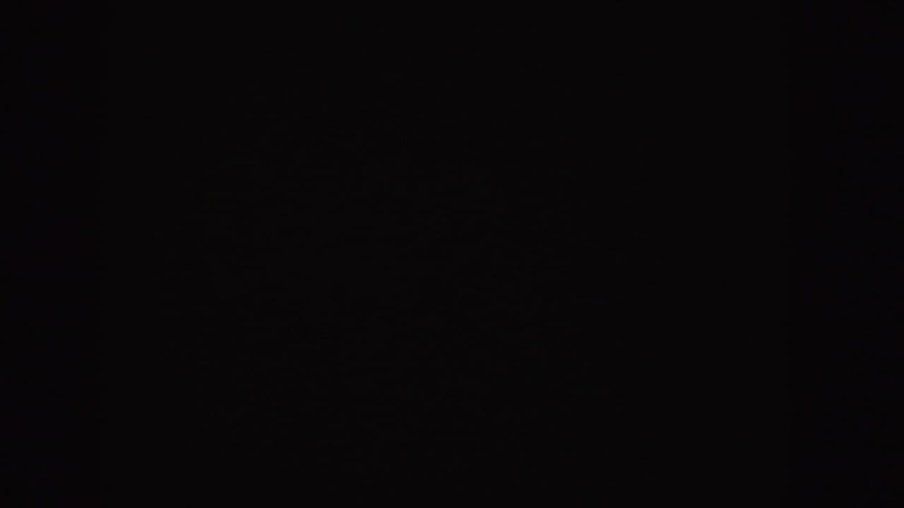 Nearly black 1955 Idaho 8mm frame with faint film grain and no identifiable scene or subject visible.