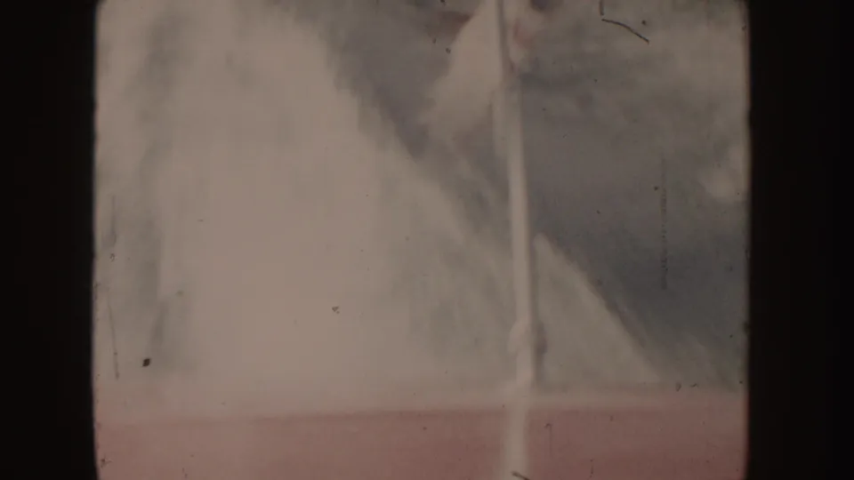 1955 Idaho 8mm frame with a soft, blurred view of boat wake, water, and shoreline from onboard.