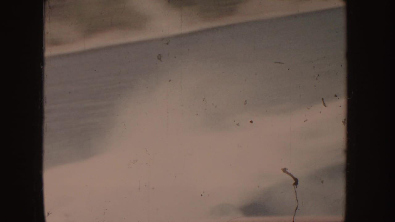 Pale surf and blurred water movement with dark frame edges.