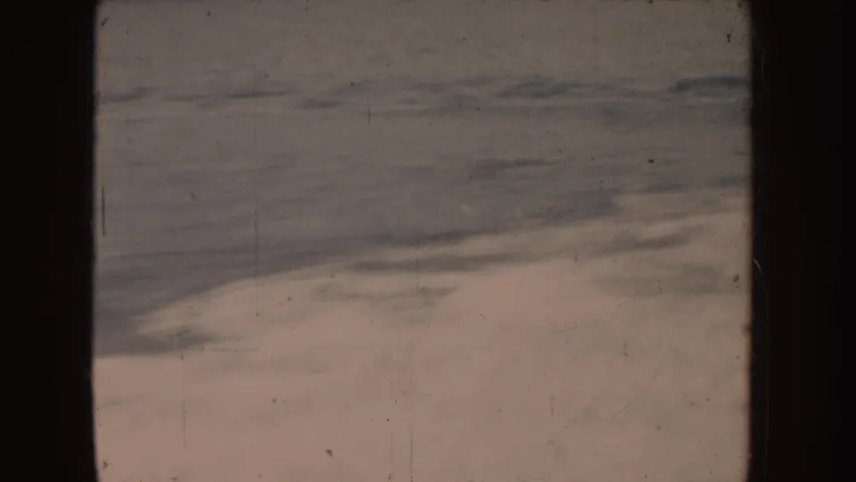 1955-attributed 8mm frame of choppy water and pale foam, marked by dust, scratches, and soft exposure.