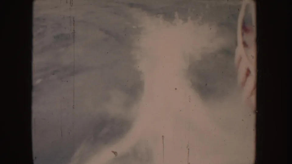 1955 Idaho 8mm frame showing pale boat spray and water texture, partly obscured by dark vertical edge shadows.