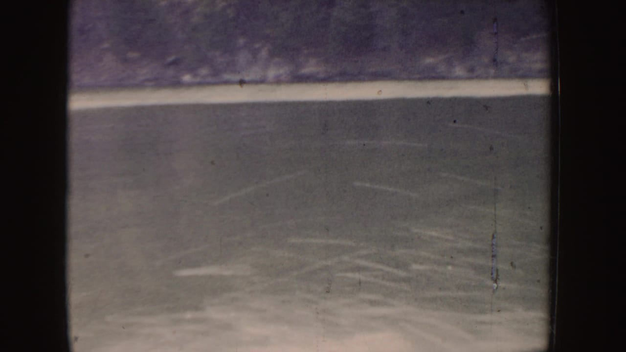 Rippling lake water with pale wake marks and dark film borders.