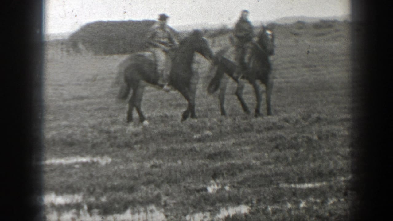 Two adults ride horses side by side in a grassy Montana field in 1939 home-movie footage.