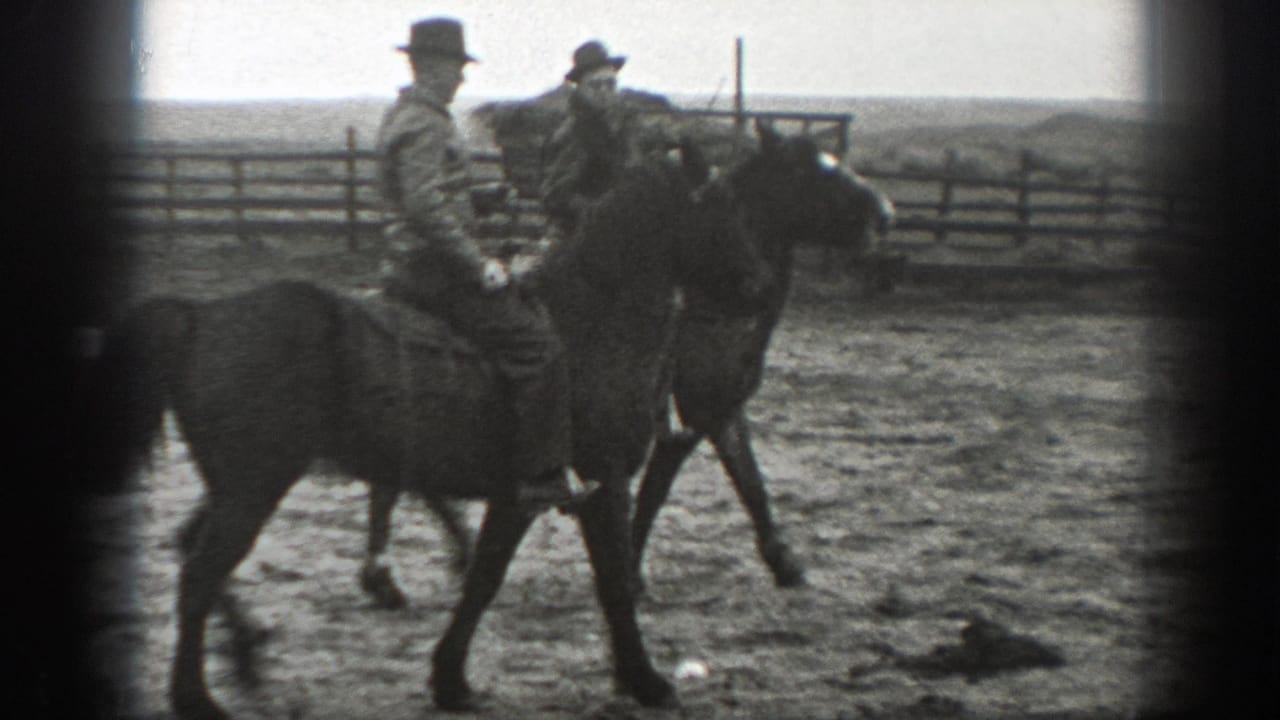 Two adult riders on saddled horses move through a dusty Montana enclosure in 1939 home-movie footage.