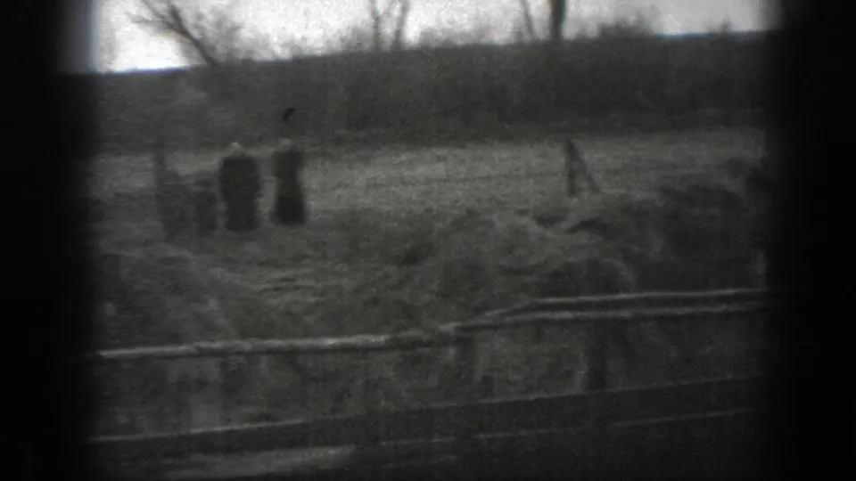 1939 Montana 8mm frame showing cattle near a muddy waterhole, with a person standing beyond fence rails in open pasture.