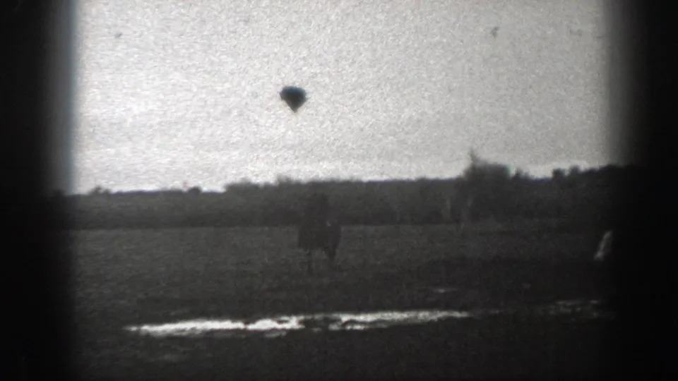 1939 Montana 8mm frame with a distant horseback rider moving across an open field, with treeline and heavy film-edge vignetting.