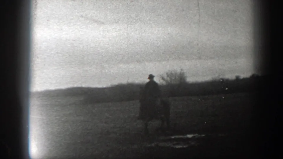 1939 Montana 8mm frame showing a lone horseback rider silhouetted in an open rural field beneath a hazy sky.