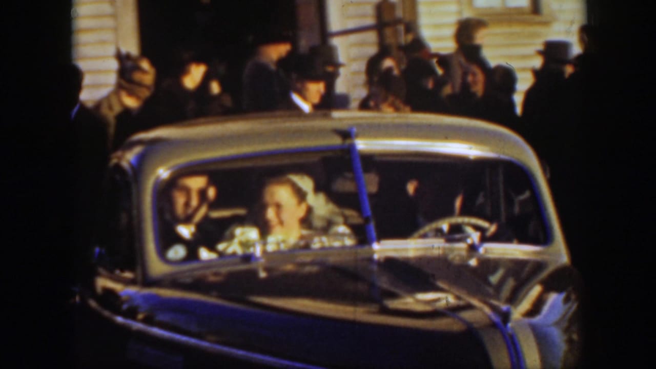 A bride and groom sit in a decorated automobile after a 1939 Montana church celebration, surrounded by guests outside.