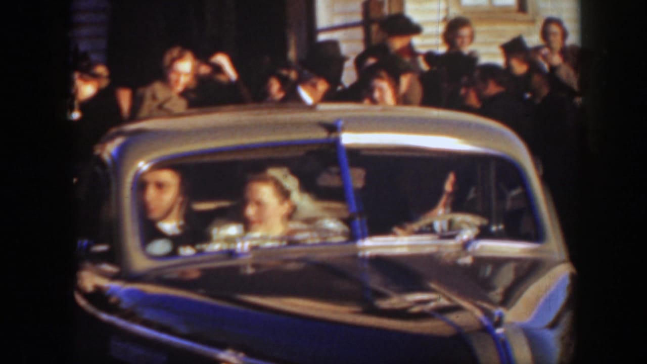 A 1939 Montana wedding sendoff shows the bride and groom inside the car with guests and a building facade behind them.