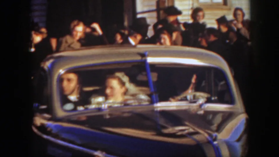A 1939 Montana wedding sendoff shows the bride and groom inside the car with guests and a building facade behind them.