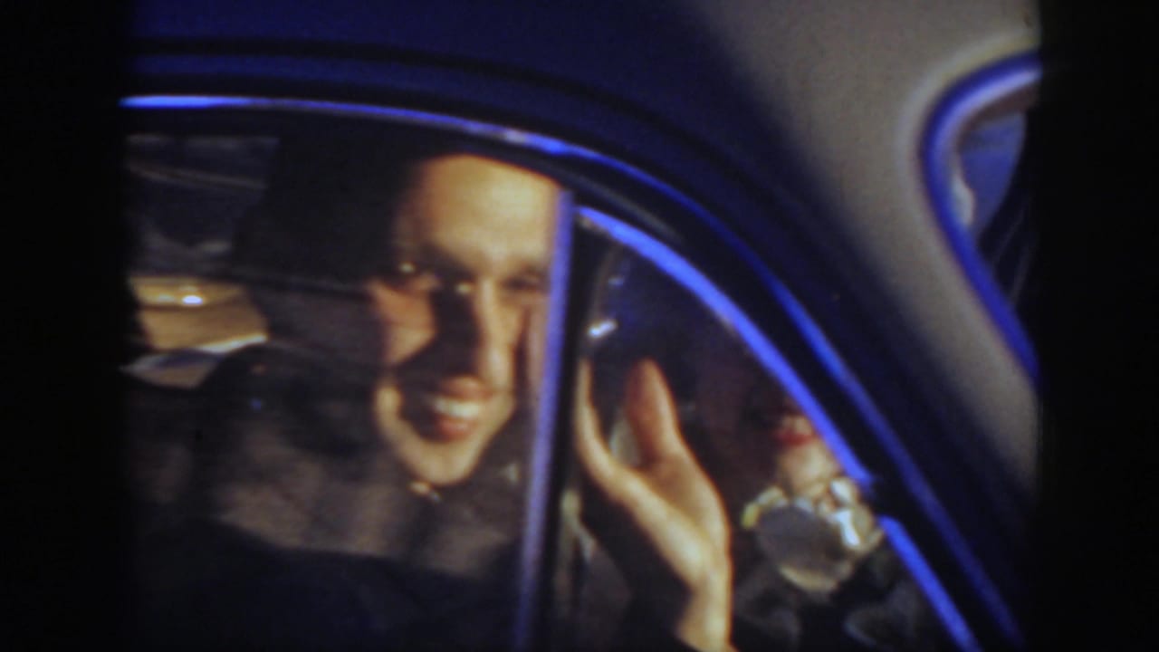 Close 1939 Montana home-movie view of the bride smiling and waving from inside the wedding car.