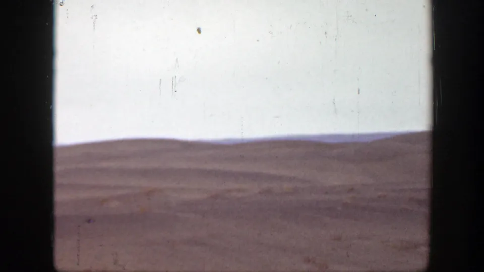 Soft 8mm frame of Montana plains in 1939, showing distant rolling ground beneath a bright pale sky.