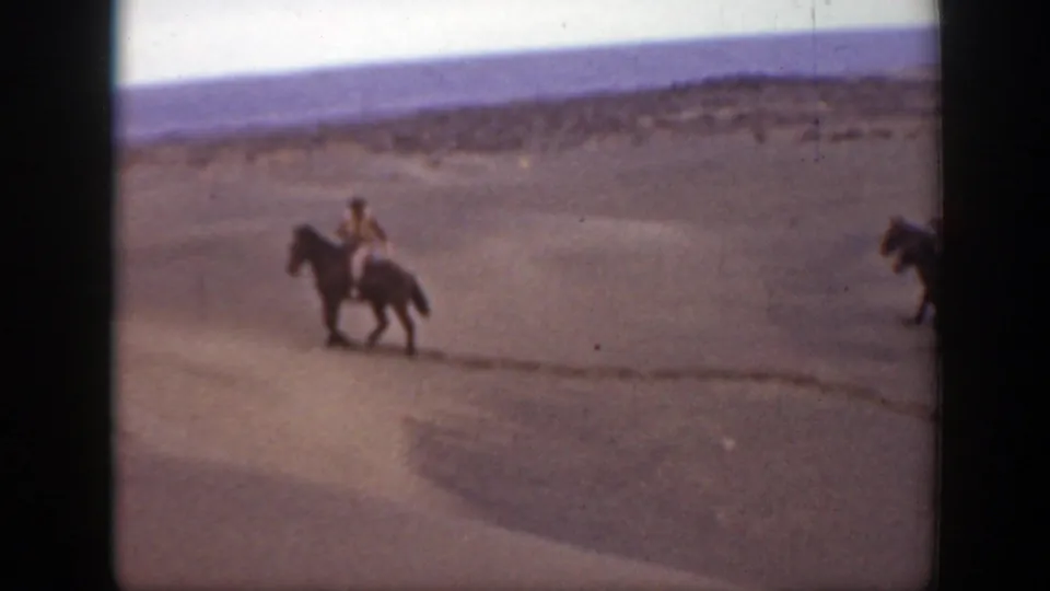 1939 Montana 8mm frame showing a horseback rider in a sandy open area, with another horse partly entering the edge of frame.