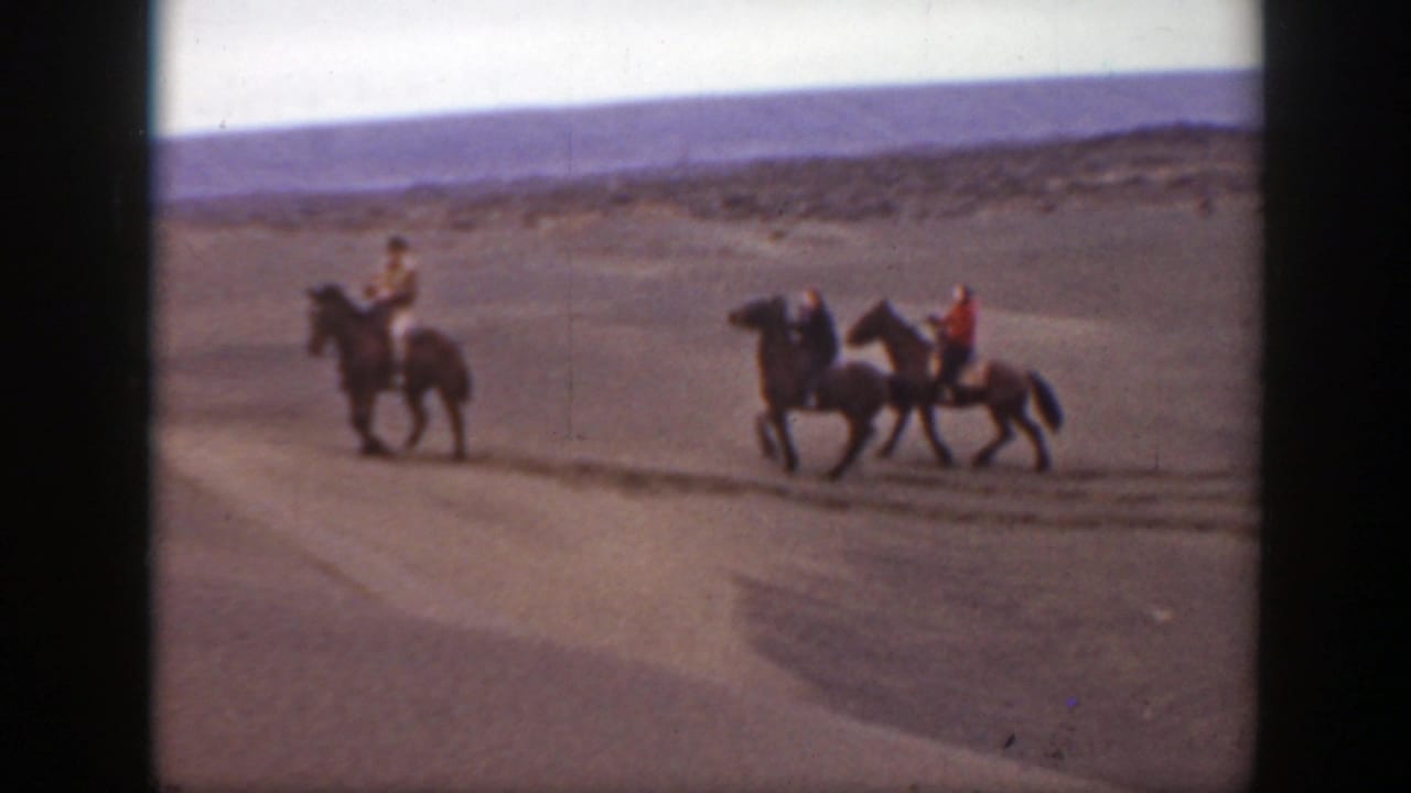 Three horseback riders traverse a sandy open landscape in archival 8mm footage identified as Montana, 1939.