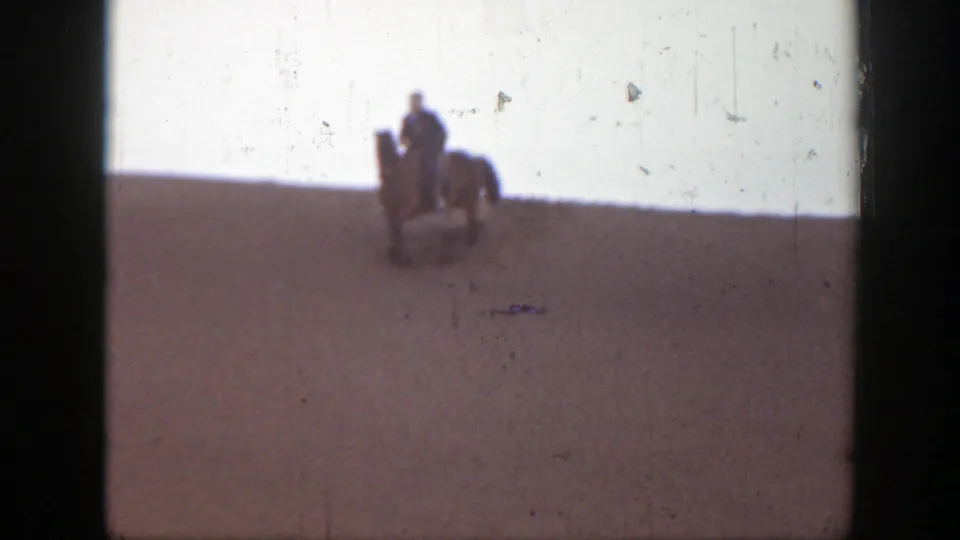 In this 1939 Montana 8mm frame, a rider on horseback descends the sandy hillside, filmed from a distant home-movie viewpoint.