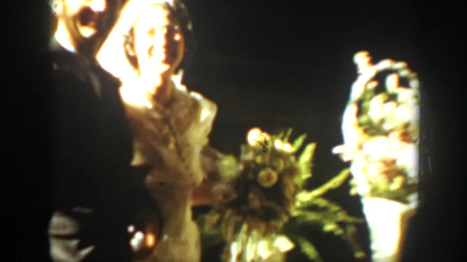 A bright 1939 Montana wedding frame shows formal figures near large floral arrangements, with the bride partly overexposed by indoor light.
